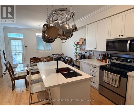 A kitchen with white cabinets and a large island with a sink.