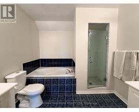 A bathroom with a white toilet and a white bathtub.