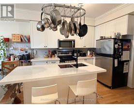 A kitchen with a white countertop and a black refrigerator.