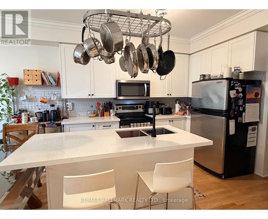 A kitchen with a white countertop and a black refrigerator.