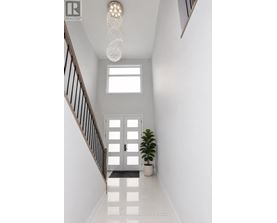 A white hallway with a plant and a chandelier.