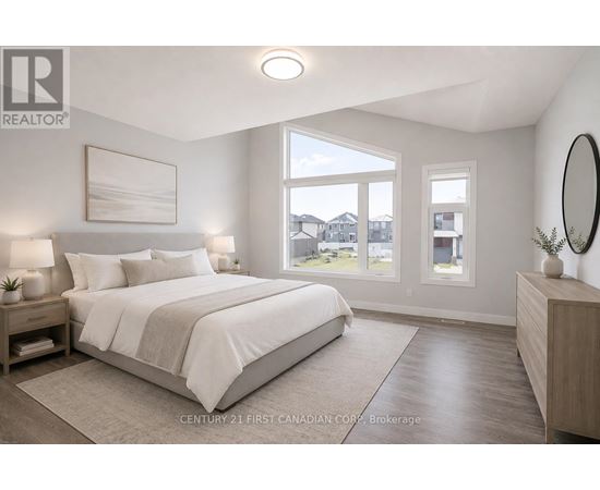 A bedroom with a large bed, a nightstand with a lamp, and a view of the outdoors through a window.