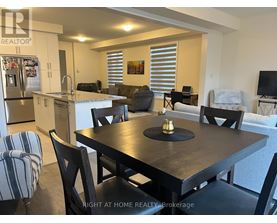 A dining room with a table set for two and a refrigerator in the corner.