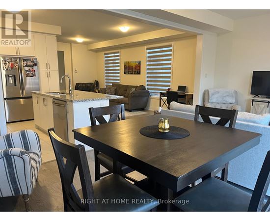 A dining room with a table set for two and a refrigerator in the corner.