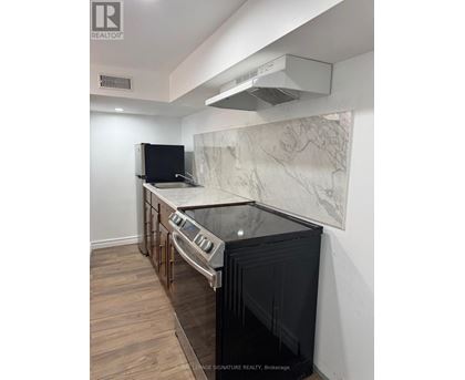 A kitchen with a black oven and a marble backsplash.