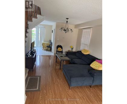 A living room with a grey couch and a wooden floor.