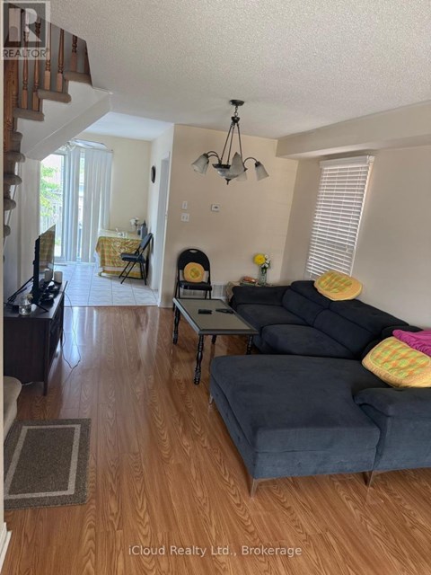 A living room with a grey couch and a wooden floor.