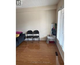Two chairs are placed in a room with a couch and a table with a tablecloth.