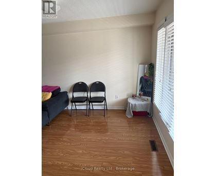 Two chairs are placed in a room with a couch and a table with a tablecloth.