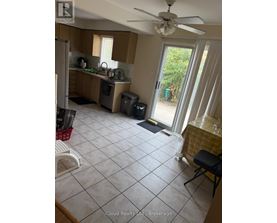 A kitchen with a table set for one in front of a sliding glass door.