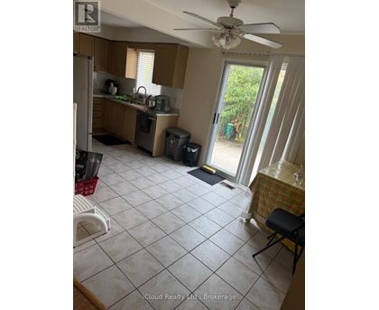 A kitchen with a table set for one in front of a sliding glass door.