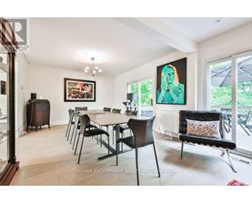 A dining room with a table set for six and a painting on the wall.