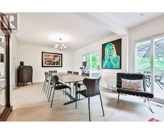 A dining room with a table set for six and a painting on the wall.