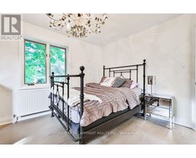 A bedroom with a large bed and a chandelier.
