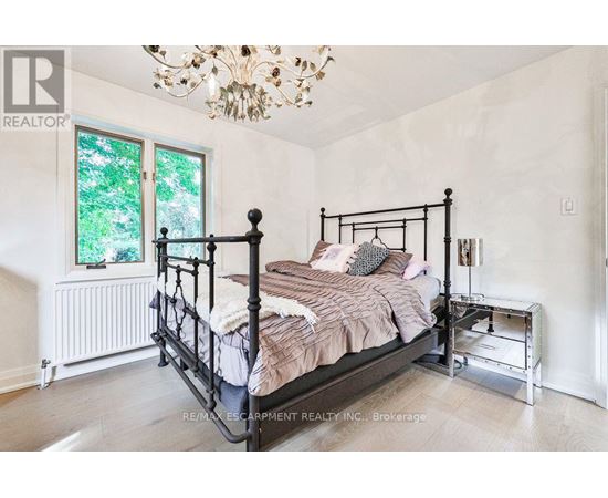 A bedroom with a large bed and a chandelier.