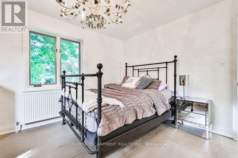 A bedroom with a large bed and a chandelier.