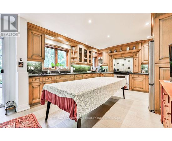 A kitchen with wooden cabinets and a large island in the middle.