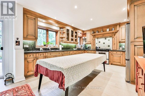 A kitchen with wooden cabinets and a large island in the middle.