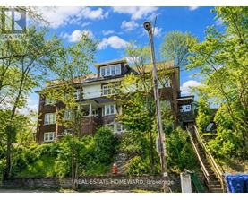 A large brown house with a staircase leading up to it.