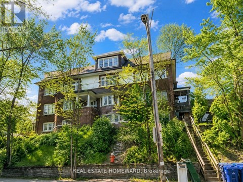 A large brown house with a staircase leading up to it.