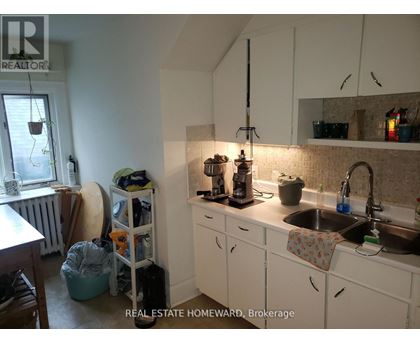 A kitchen with white cabinets and a sink.