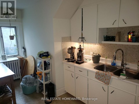 A kitchen with white cabinets and a sink.