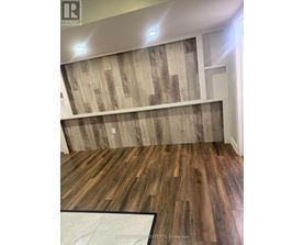 A room with wooden flooring and a wooden wall paneling.
