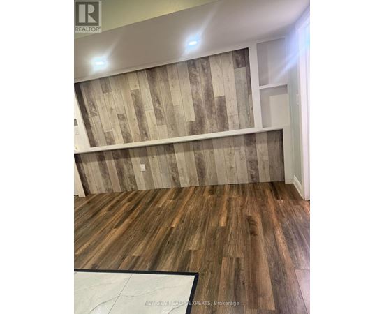 A room with wooden flooring and a wooden wall paneling.