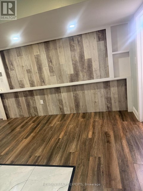 A room with wooden flooring and a wooden wall paneling.