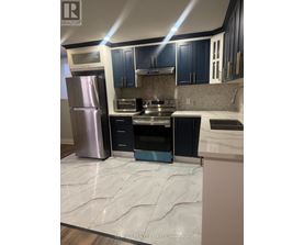 A kitchen with a refrigerator, oven, and microwave.