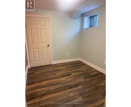A room with a wooden floor and a white door.