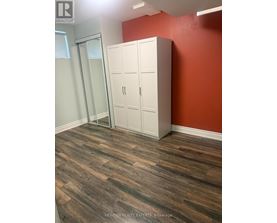A room with a wooden floor and a white wardrobe.