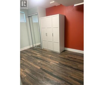 A room with a wooden floor and a white wardrobe.