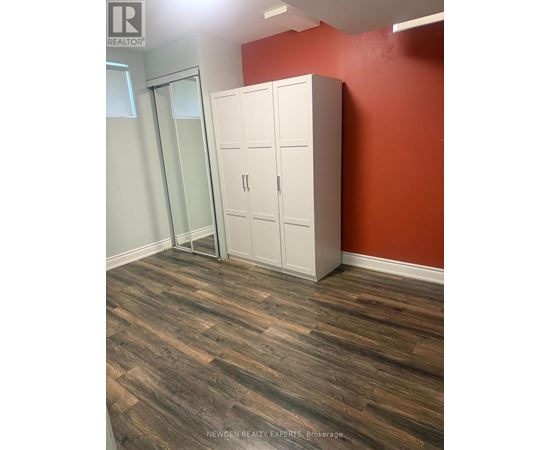 A room with a wooden floor and a white wardrobe.