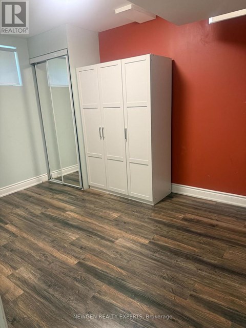 A room with a wooden floor and a white wardrobe.