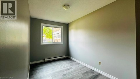 A room with a window and a wooden floor.