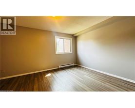 A room with a window and wooden flooring.