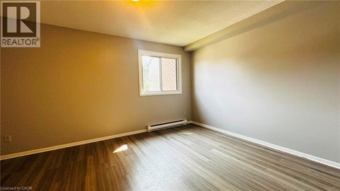 A room with a window and wooden flooring.