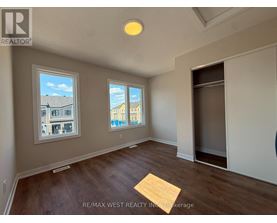 A room with a window showing a view of a building and another window showing a view of the sky.