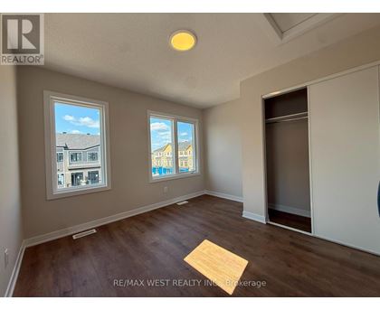 A room with a window showing a view of a building and another window showing a view of the sky.