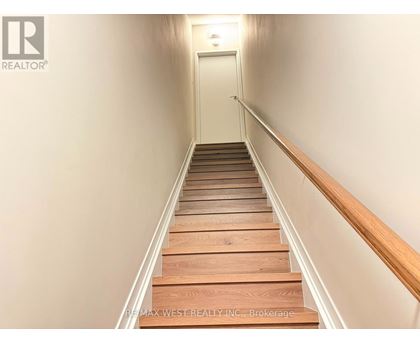 A long flight of wooden stairs leads to a door at the end.