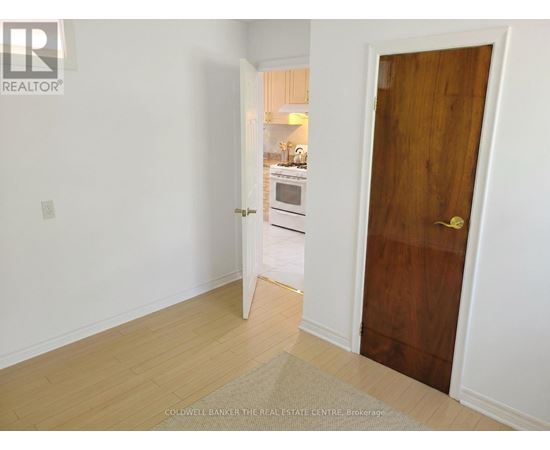 A room with a wooden door and a white wall.