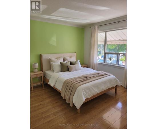 A bedroom with a bed, nightstand, and window.