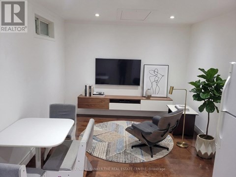 A modern living room with a white table and grey chairs.