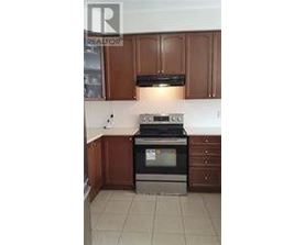 A kitchen with brown cabinets and a black stove top oven.