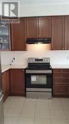 A kitchen with brown cabinets and a black stove top oven.