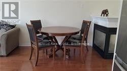 A dining room with a table and chairs.