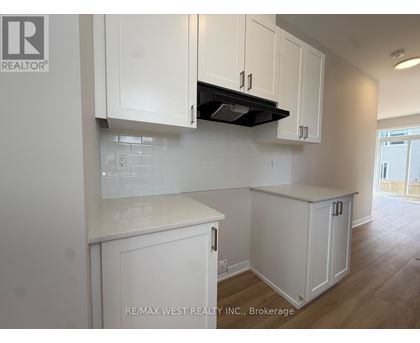 A kitchen with white cabinets and a black stove top.