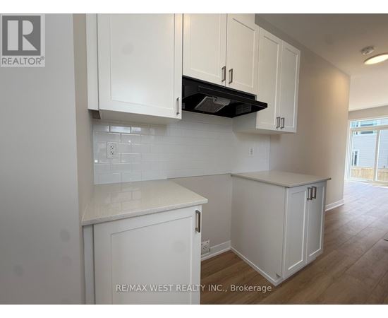 A kitchen with white cabinets and a black stove top.