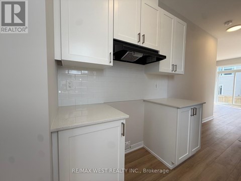 A kitchen with white cabinets and a black stove top.